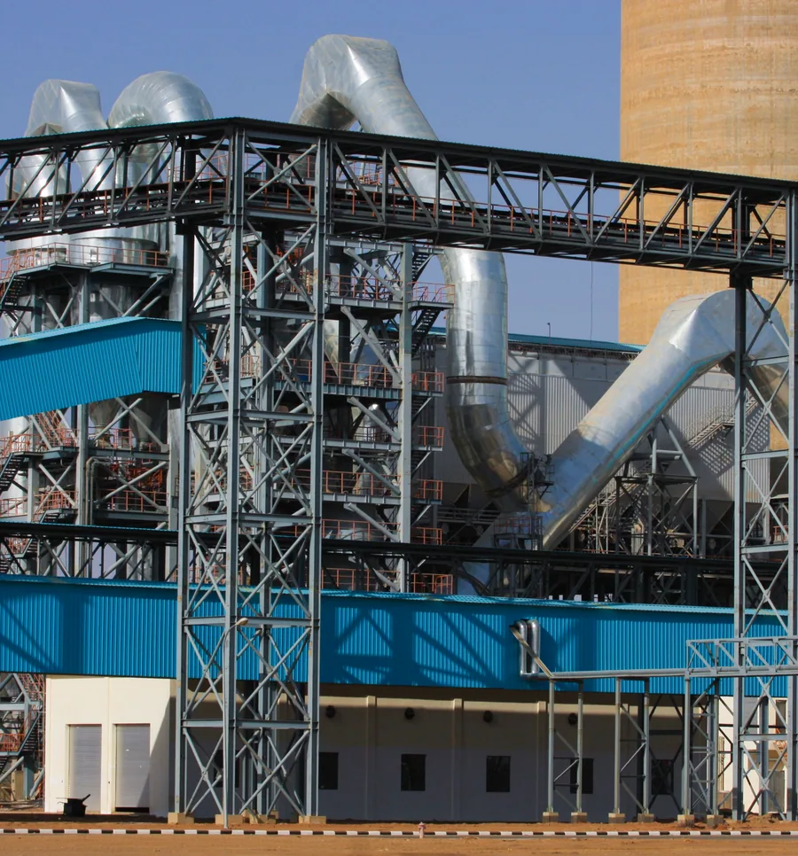 Industrial plant with pipe bridges, ducting and process equipment.